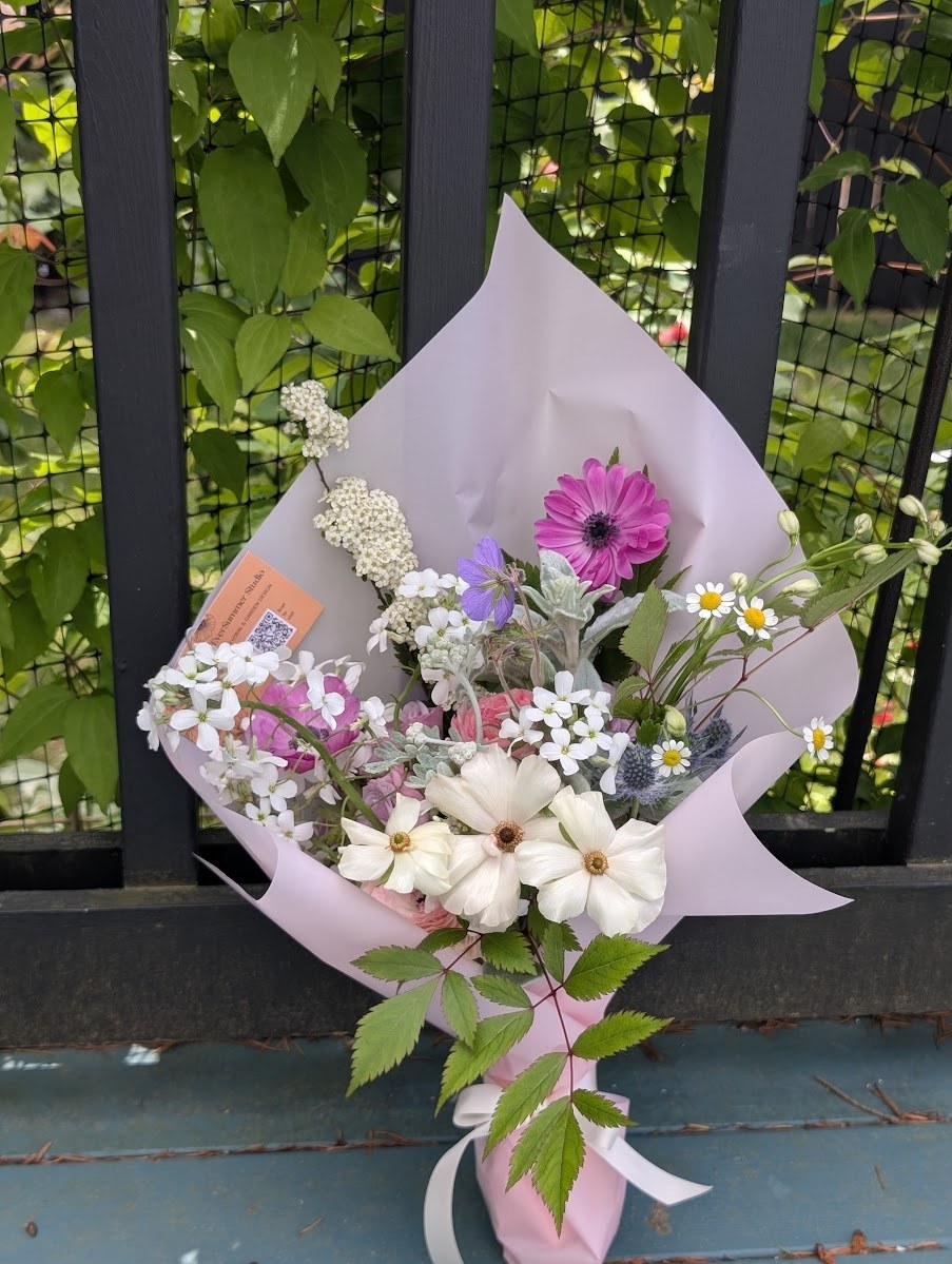 Recital bouquet in soft pink and white — pink gerbera, white cosmos, chamomile, sea holly, and lacy phlox